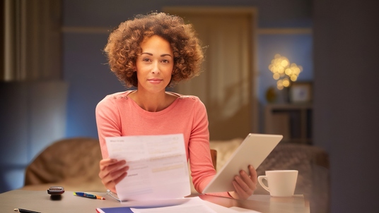 Woman going over bills at a table.
